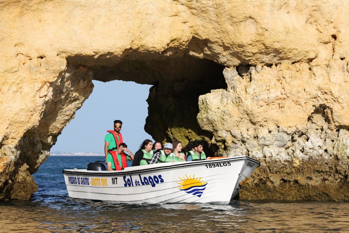 O barco do Sol de Lagos a passar debaixo de um arco na Ponta da Piedade
